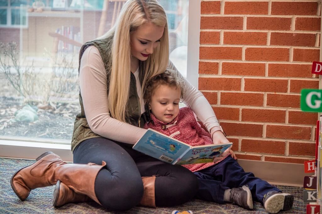 mom reading to child in library