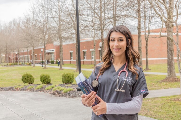 woman posing outside in nurse scrubs