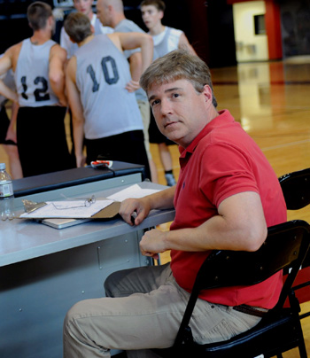 John Henson sitting at scorers table during basketball game