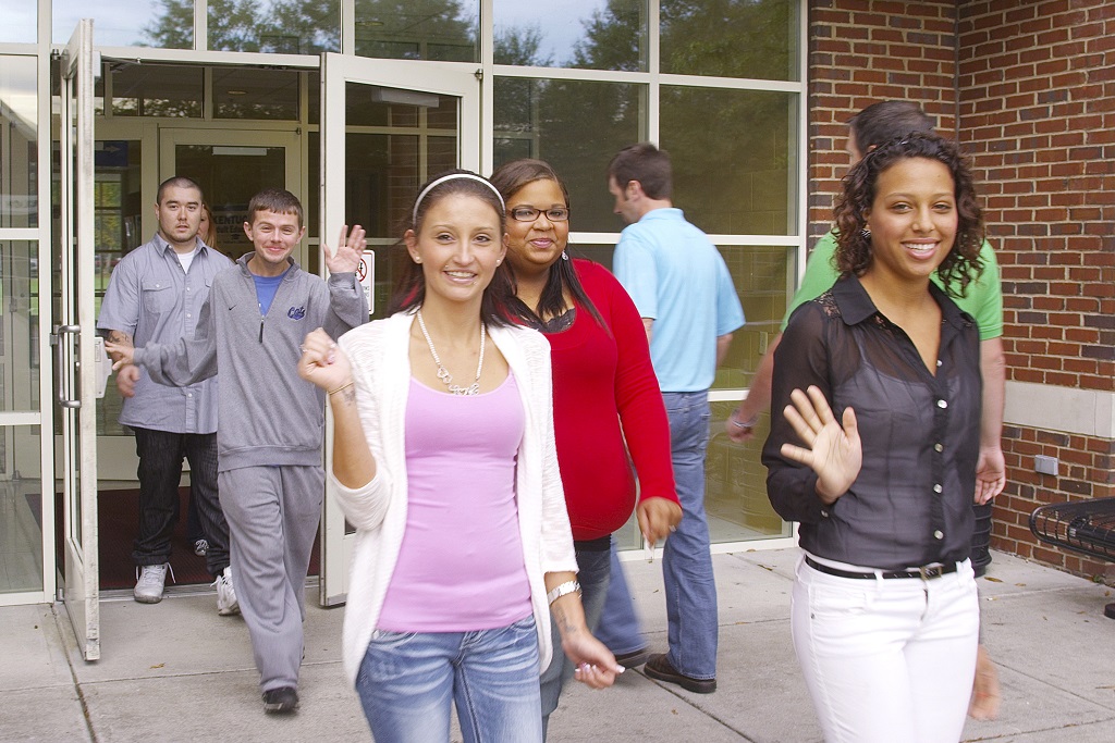 students walking out of building on campus