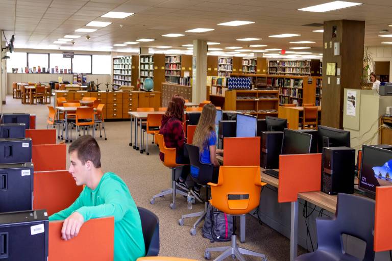 students working at desktop computers in the library