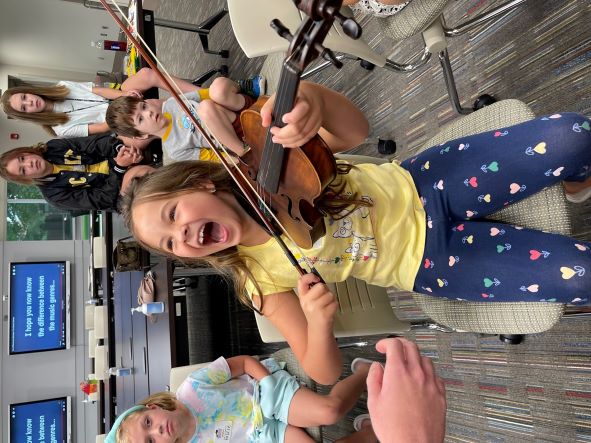 Harper Joy is smiling big with a fiddle in her hand.