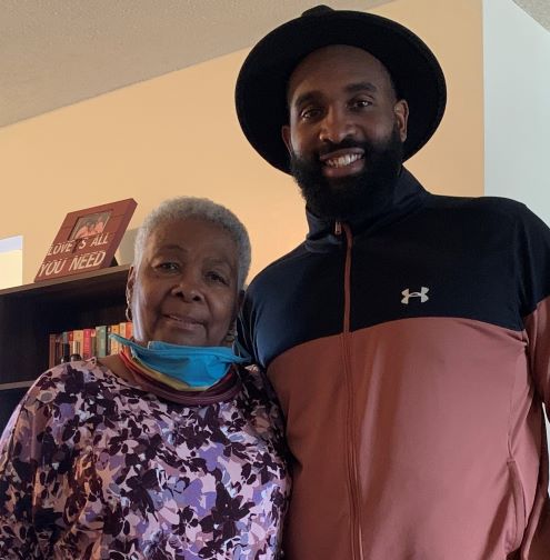 Meau Jones poses for a photograph with an older woman.