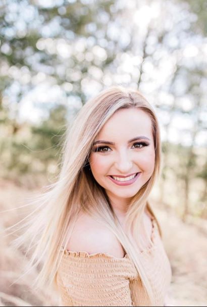 Sierra Mullins posing for a photograph outside.