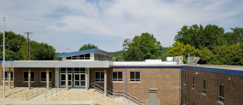 A photograph of the Knox Campus exterior. A blue sky with clouds is part of the photo.