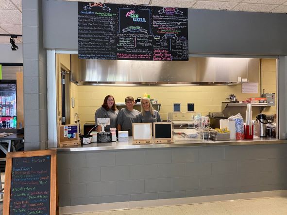 From L--Two Gen Grill employees Leatha Givens and Kaelyn Cole join owner Courtney Eldridge in the Southeast Middlesboro Campus grill.