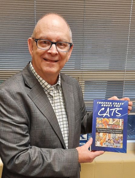 A photo of Jamie Vaught holding his latest book, Crazy About the Cats.