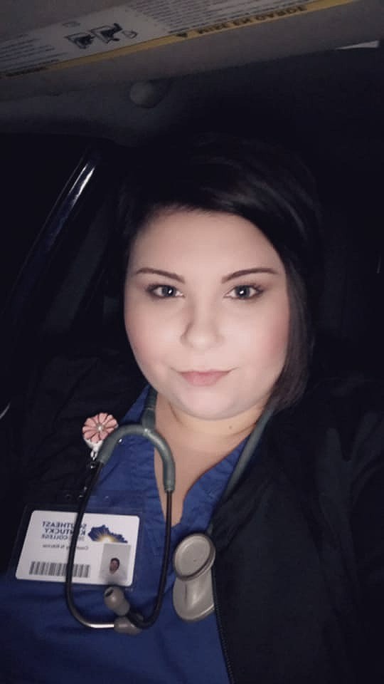 A photo of Courtney Ritchie, a female, smiling while wearing respiratory care scrubs.