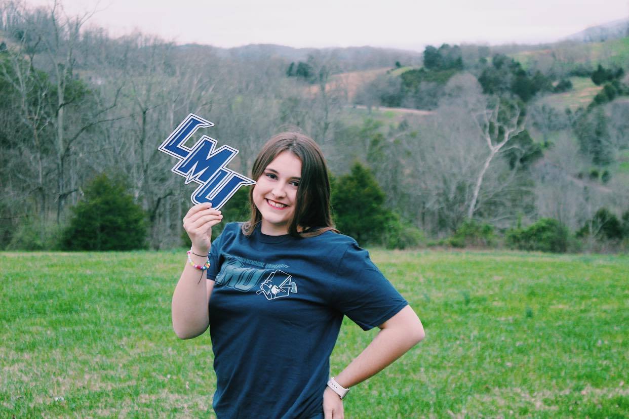 A portrait of Gracie Moles. She is holding a LMU sign while wearing a LMU shirt.