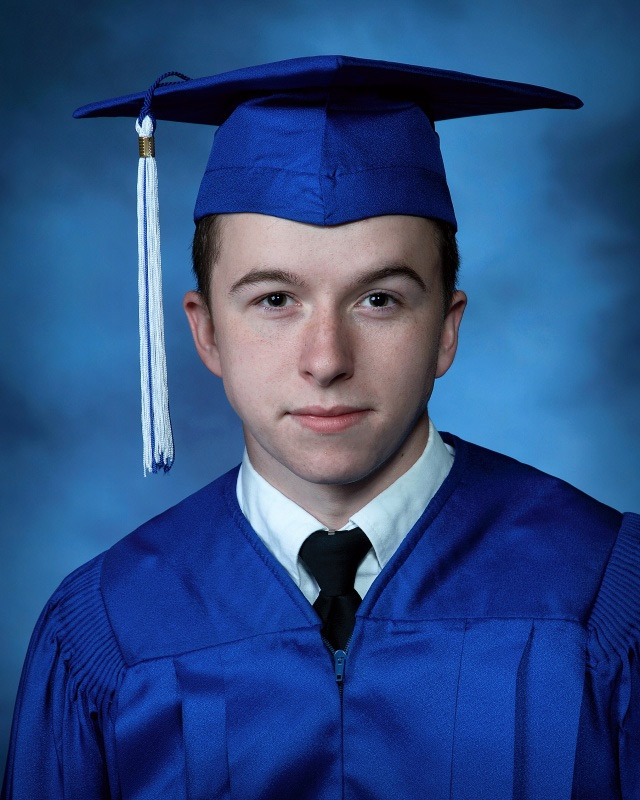 A head shot photograph of Hayden Prater wearing a blue graduation cap and gown.