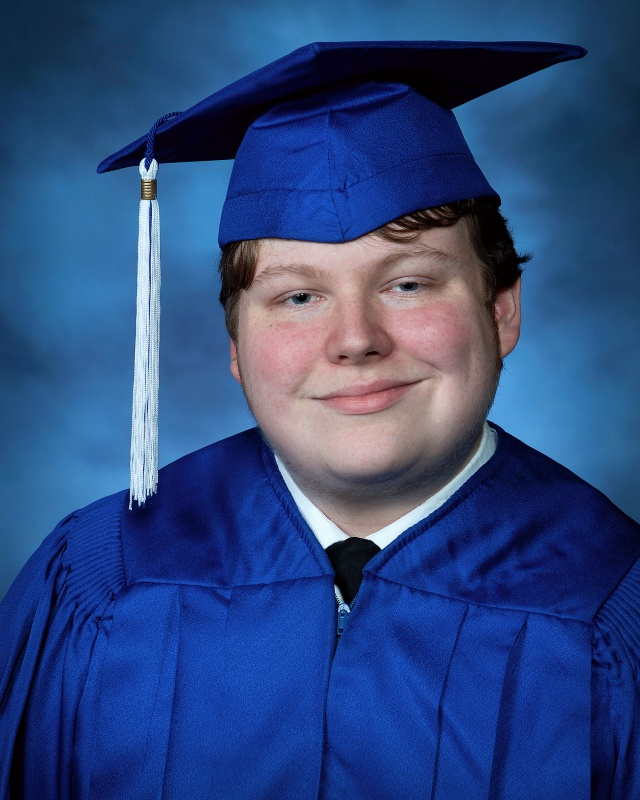 A head shot photograph of John Perkins wearing a blue graduation cap and gown.