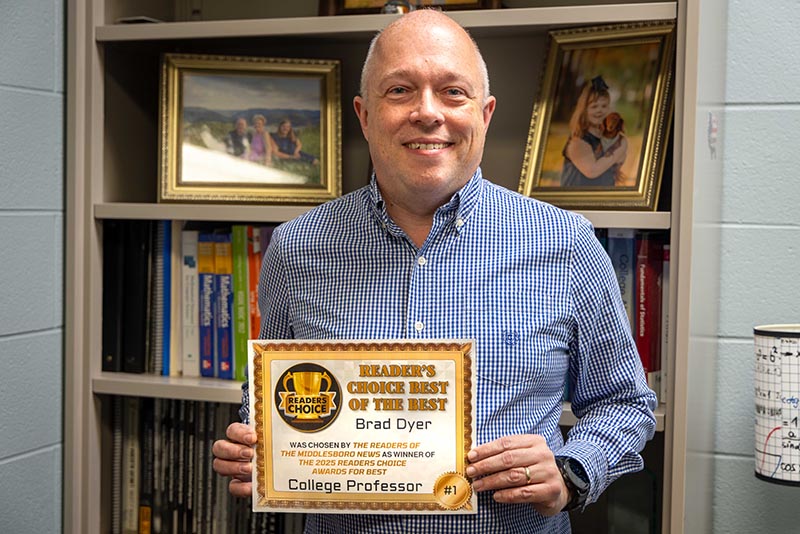 Bray Dyer holding his Readers' Choice Award for Best College Professor