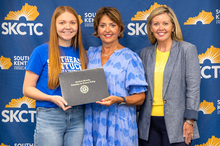 Addison Seigler (left) receives the Mike Bowling Memorial Scholarship during Southeast Kentucky Community & Technical College's Scholarship Signing Day. Joining Seigler are Jamie Bowling, widow of Mike Bowling, and Rian Johnson, dean of advancement and public relations at SKCTC.