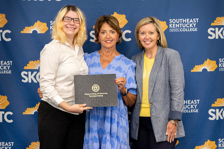 Haven Branham (left) receives the Mike Bowling Memorial Scholarship during Southeast Kentucky Community & Technical College's Scholarship Signing Day. Joining Branham are Jamie Bowling, widow of Mike Bowling, and Rian Johnson, dean of advancement and public relations at SKCTC.