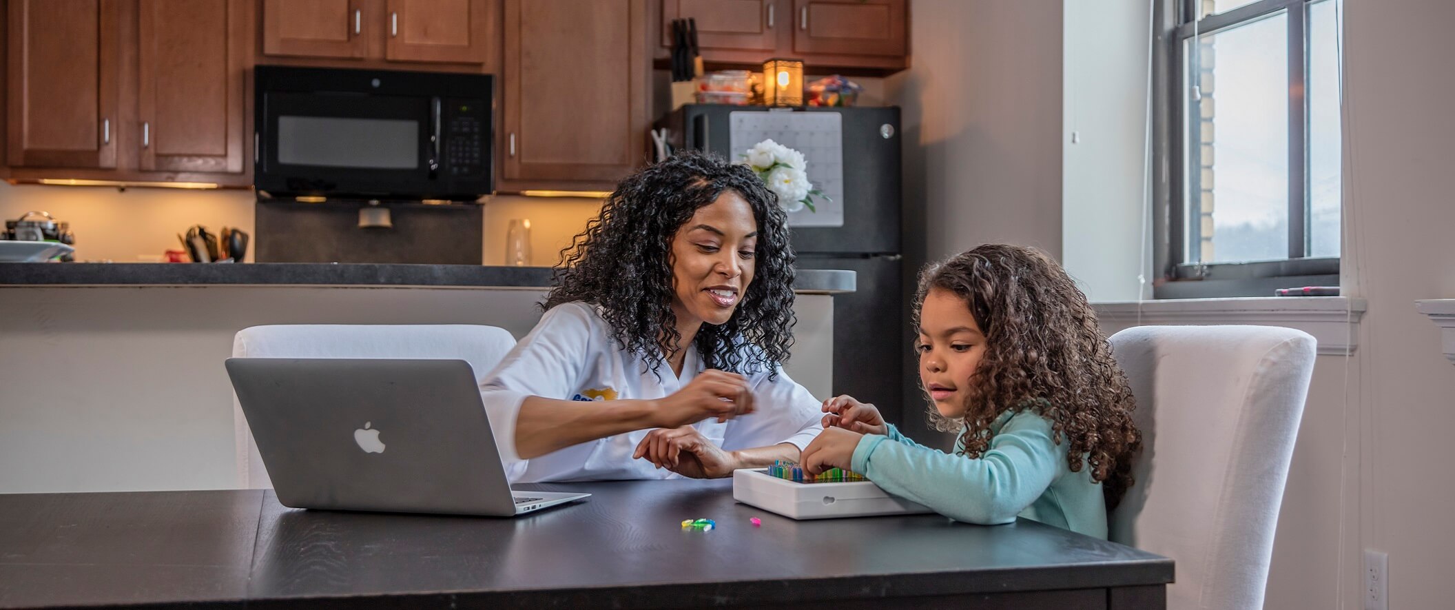 mom and daughter in kitchen on laptop
